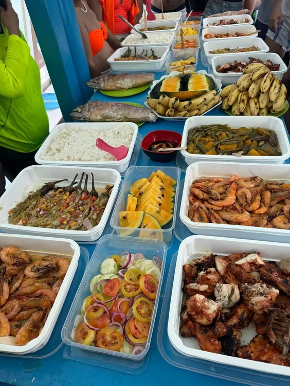 El Nido boat lunch spread of grilled meat, seafood, vegetables and fruit